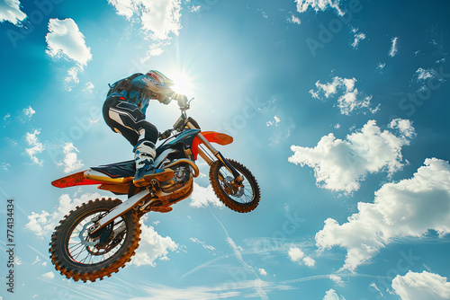 Adrenaline pumps as Colorful Motor cross or Moto X extreme rider is jumping through the air on a bright sunny day