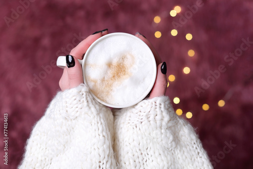 Wallpaper Mural Coffee cup on the background of a fluffy blanket with lights. A mug with cappuccino in female hands Torontodigital.ca