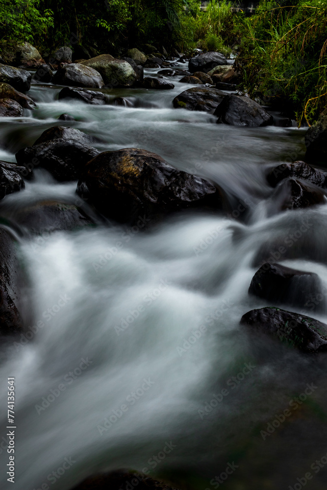 Naklejka premium Stream water long exposure shot with rocks