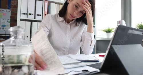 Sad depressed woman looking at financial accounts. Debts and bankruptcy concept
