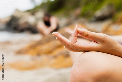 Hands of a young girl performing yoga asana pose on the beach