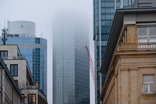 skyscrapers buildings disappear into the mist, creating mysterious and atmospheric urban landscape with blurred outlines and obscured details, Weather Conditions, German Engineering