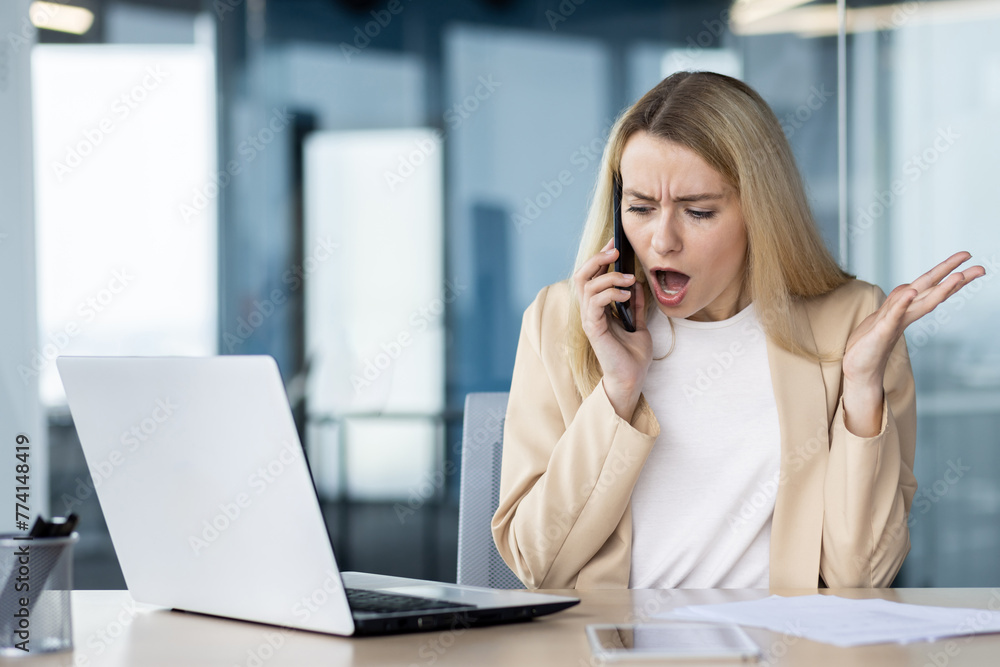 Frustrated businesswoman arguing on the phone at her desk Frustrated businesswoman arguing on the phone at her desk