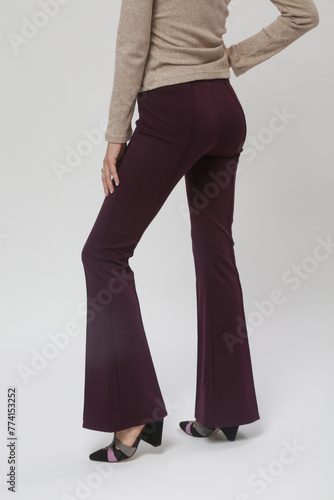 Serie of studio photos of young female model wearing basic flared purple trousers and triangle heel suede sandal