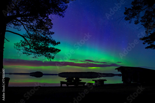 Northern light dancing over calm lake in north of Sweden.Farnebofjarden national park. photo