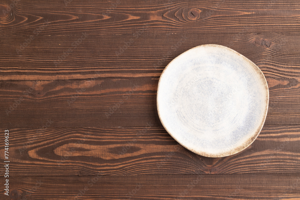 Empty blue and white ceramic plate on brown wooden. Top view, copy space Empty blue and white ceramic plate on brown wooden. Top view, copy space