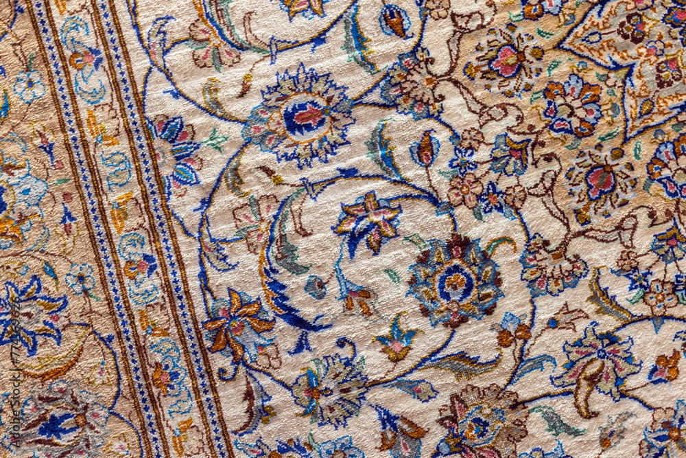 Oriental silk carpet with colorful floral pattern, close-up