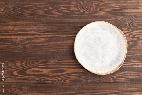 Empty blue and white ceramic plate on brown wooden. Top view, copy space