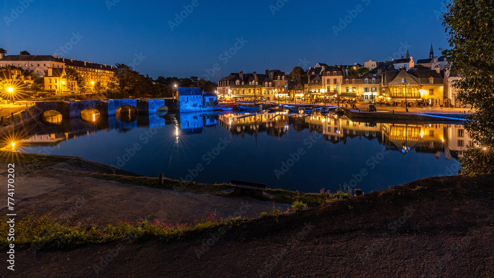 Die beleuchtete Stadt Port de St Goustan spiegelt sich im Fluss in der blauen Stunden, Bretagne