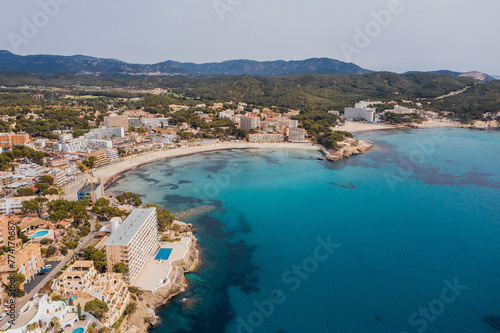 Fototapeta Naklejka Na Ścianę i Meble -  Beautiful aerial drone view shot of Peguera town on rocky Mediterranean cliff coast with cozy tranquil turquoise bays washed with sea waves. Traveling and Balearic Islands vacation concept
