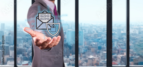 cybersecurity and data protection concept. executive holds hologram of envelope with shield and padlock.