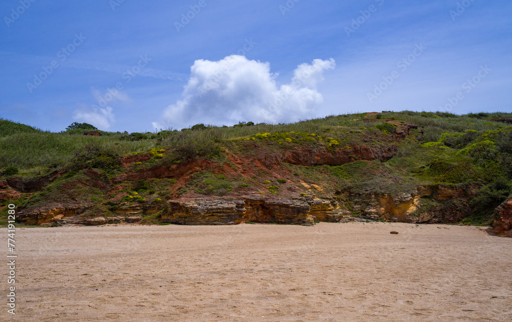 Shell rock coastal cliffs and sandy beach on the Atlantic coast, Portugal
