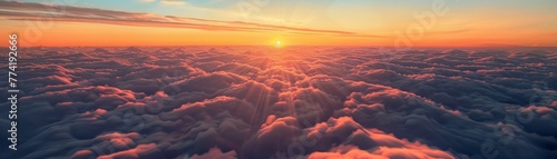 A canopy of clouds seen from above with the sun setting on the horizon photo