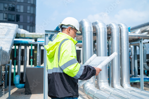 Engineer reads asbuil drawings to inspect chiller water pipes