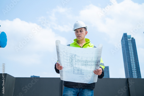 Construction Engineer Evaluating Blueprints on Rooftop