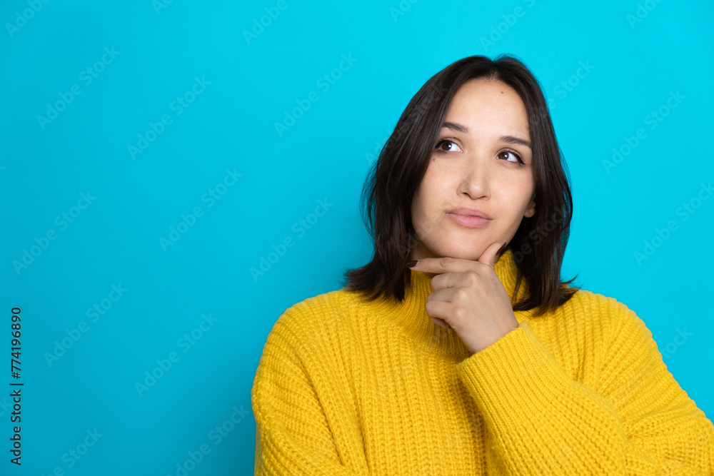 Portrait of creative woman arm touch chin look empty space brainstorming isolated on blue color background Portrait of creative woman arm touch chin look empty space brainstorming isolated on blue color background