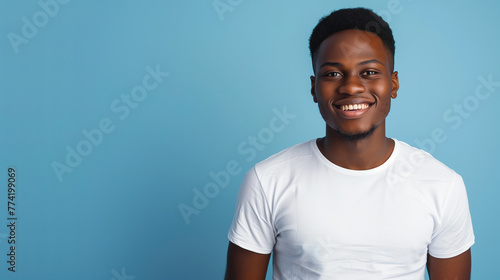 Smiling young african american man wearing white t-shirt, isolated on blue background