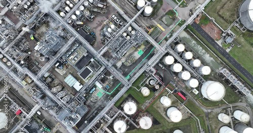 Top down aerial drone view on the chemical industry, storage containers, smoke, pipes, lines, tanks, resevoirs, smoke stacks, heavy industry in operation. Facility and installation. photo