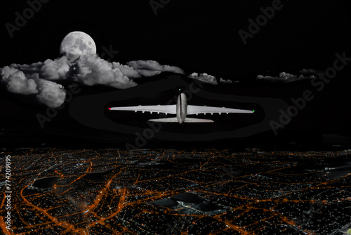Commercial jet aircraft flying over a city at night