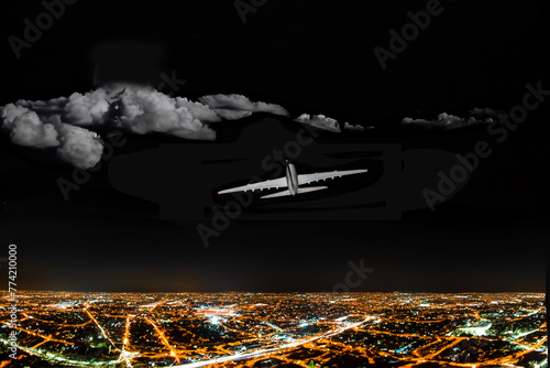 Commercial airliner flying over clouds and city at night