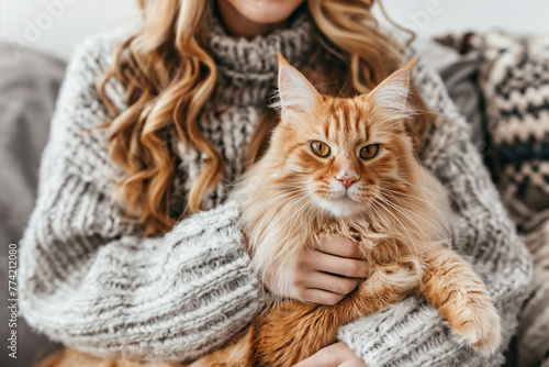 A red-haired woman hugs her ginger cat.