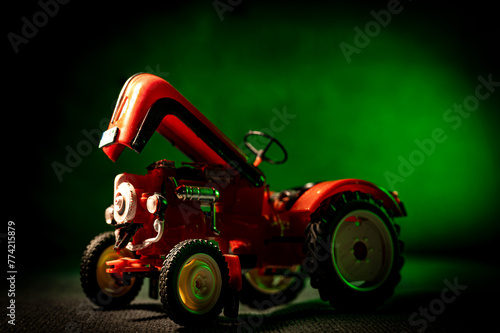 Czerwony traktor na zielonym tle.