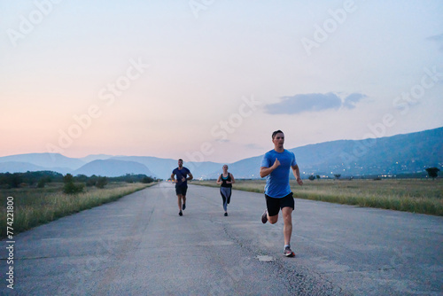A diverse group of runners trains together at sunset. © .shock