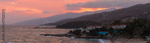 Panoramic view to the slopes and costline of western Ikaria with the fishing village Gialiskari and Mesakti beach with dramatic sky.