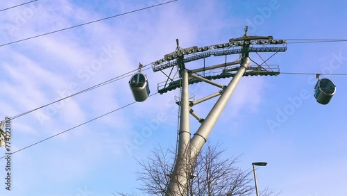 Ropeway, cable car cabins are moving against the blue sky