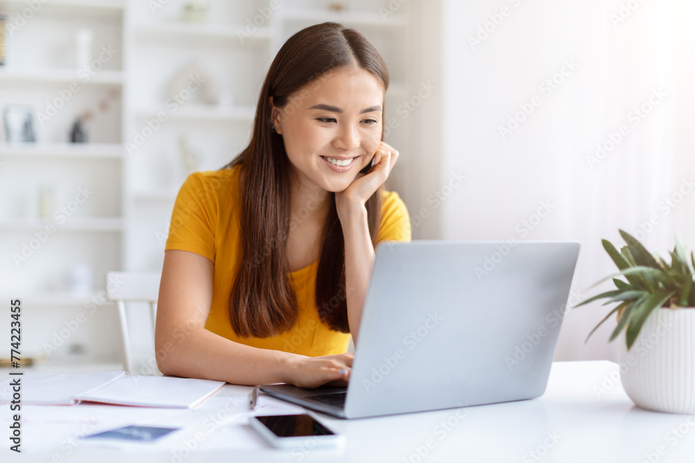Thoughtful woman with laptop at home office Thoughtful woman with laptop at home office