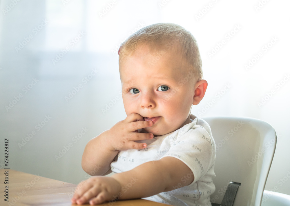 Baby boy sitting in high chair ready for eating