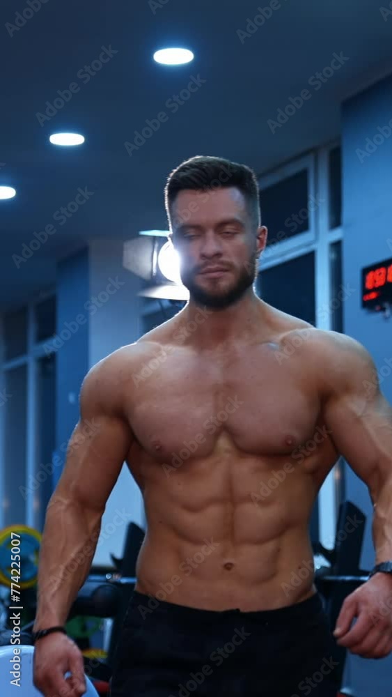 Half length portrait of shirtless sportsman. Muscular bodybuilder with naked torso in the gym. Handsome man with perfect athletic body moving to camera. Vertical video Half length portrait of shirtless sportsman. Muscular bodybuilder with naked torso in the gym. Handsome man with perfect athletic body moving to camera. Vertical video