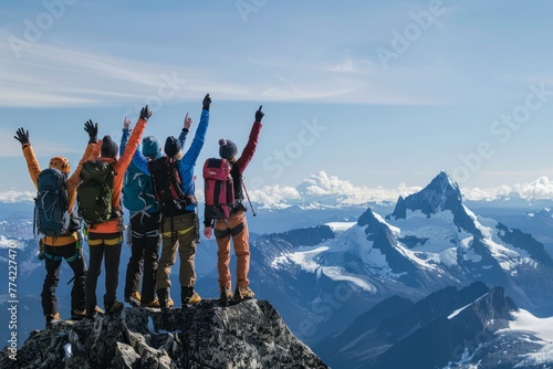 A group of hikers celebrating their achievement on the summit of a mountain, standing with arms raised in triumph