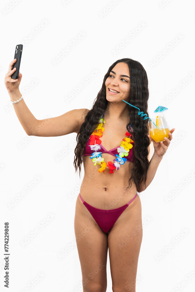 vertical Brunette Latin girl in bikini taking a selfie with her cellphone on white background vertical Brunette Latin girl in bikini taking a selfie with her cellphone on white background