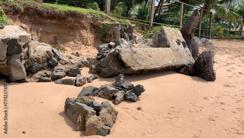 retaining wall with stones and concrete on the beach destroyed by high tide in the storm photo