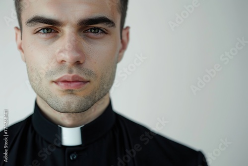 Young priest on grey background photo