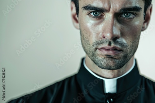 Young priest on grey background photo