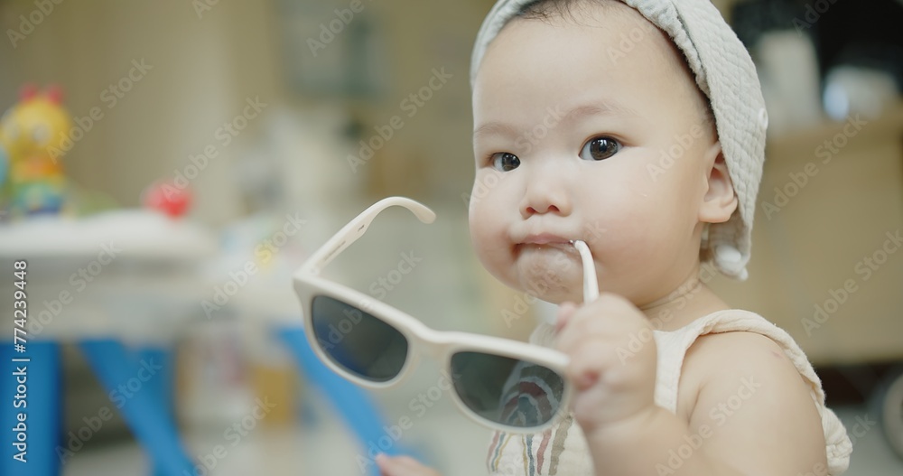 portrait happy face cute small Asian baby infant girl with sunglasses smiling at home, adorable innocent child take off fashion glasses relaxed indoors portrait happy face cute small Asian baby infant girl with sunglasses smiling at home, adorable innocent child take off fashion glasses relaxed indoors