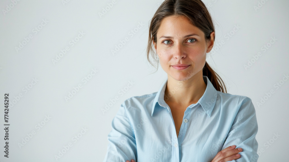 Confident Woman in Sky Blue Shirt, Arms Crossed, Pristine White Background Confident Woman in Sky Blue Shirt, Arms Crossed, Pristine White Background