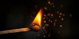 Macro photography of a matchstick as it ignites, with bright flame and sparks against a dark background.