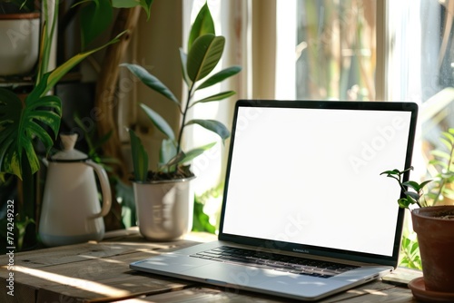 Home office empty white laptop screen on wooden table