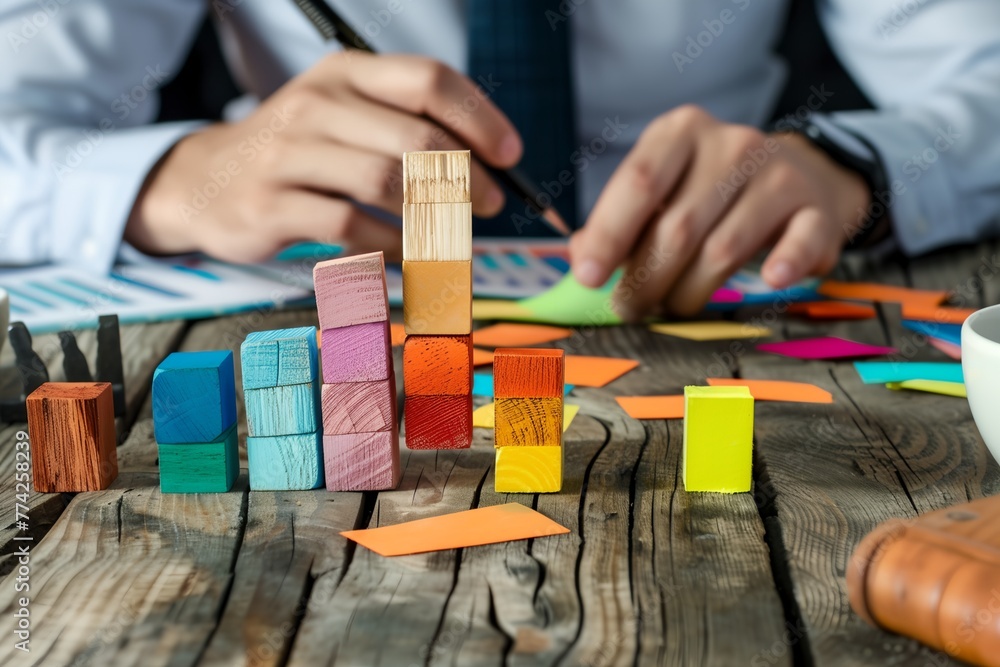 A man is building a tower out of wooden blocks A man is building a tower out of wooden blocks