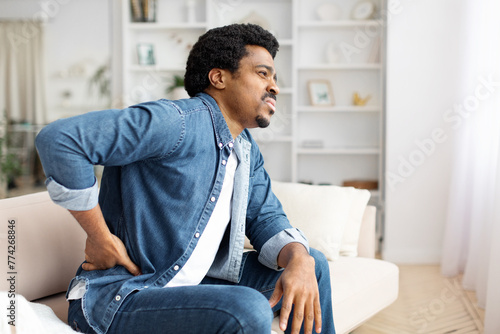 Fototapeta Naklejka Na Ścianę i Meble -  Black Man Experiencing Lower Back Pain at Home