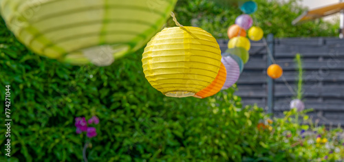 Summerly garden scene with colorful lampions hanging in a row. photo