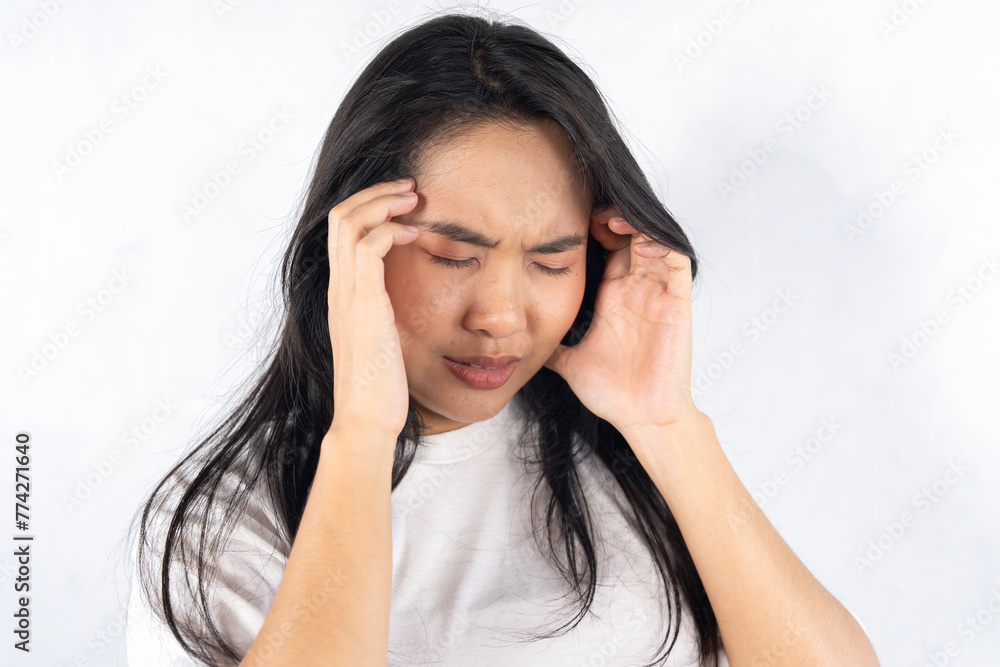 A woman with her hand on her forehead, looking worried. She is wearing a white shirt. A woman with her hand on her forehead, looking worried. She is wearing a white shirt.