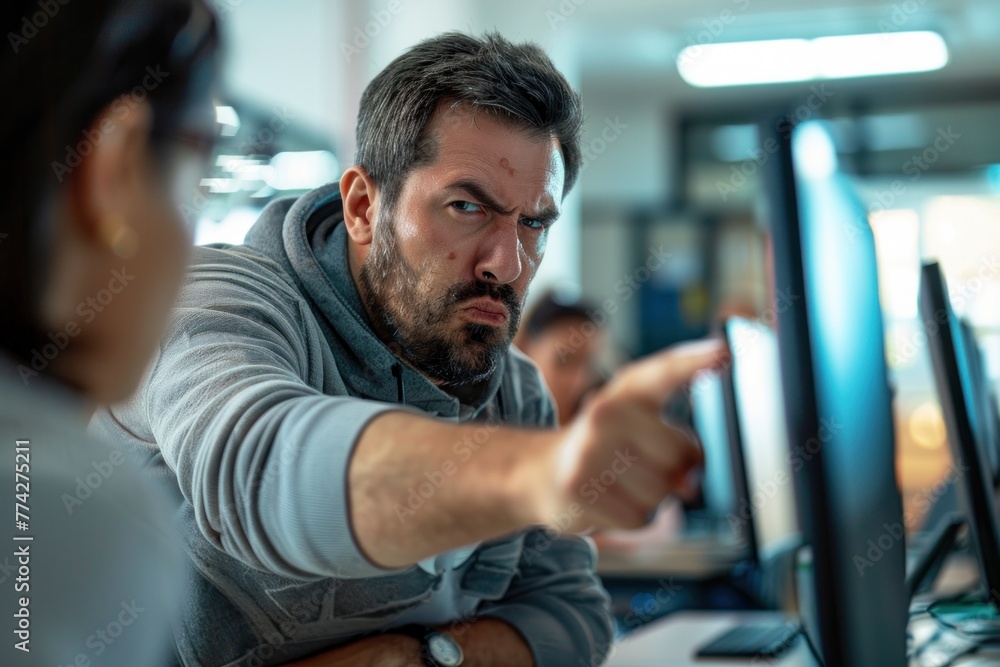 A male teacher in a computer lab pointing at a screen. A male teacher in a computer lab pointing at a screen.