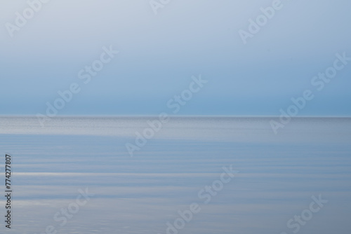 Loksa Estonia - March 31 2024: Mesmerizing dawn, where sea meets sky in perfect harmony, blending into a tranquil horizon. Serene moment captured at the break of day Hara bay, Finnish Gulf, Baltic Sea