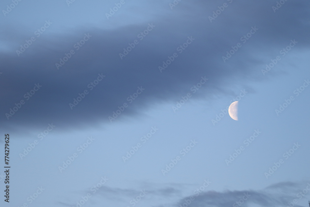 The colorful blue soft sky above the clouds with half moon The colorful blue soft sky above the clouds with half moon
