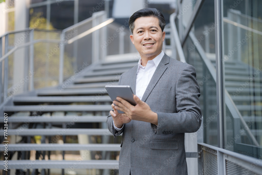 Confident businessman with tablet outdoors Confident businessman with tablet outdoors