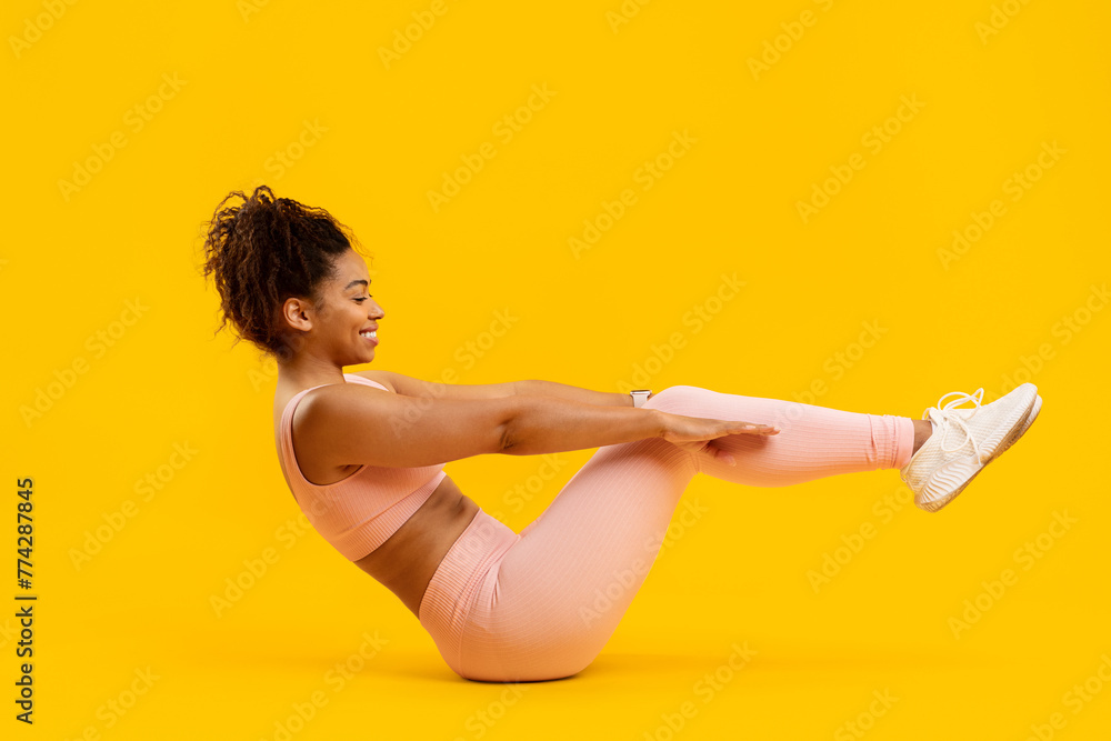 Obraz premium African american woman performing a pilates boat pose